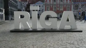 Liels Rīgas pilsētas uzraksts uz bruģētas ielas centrālajā pilsētas daļā.