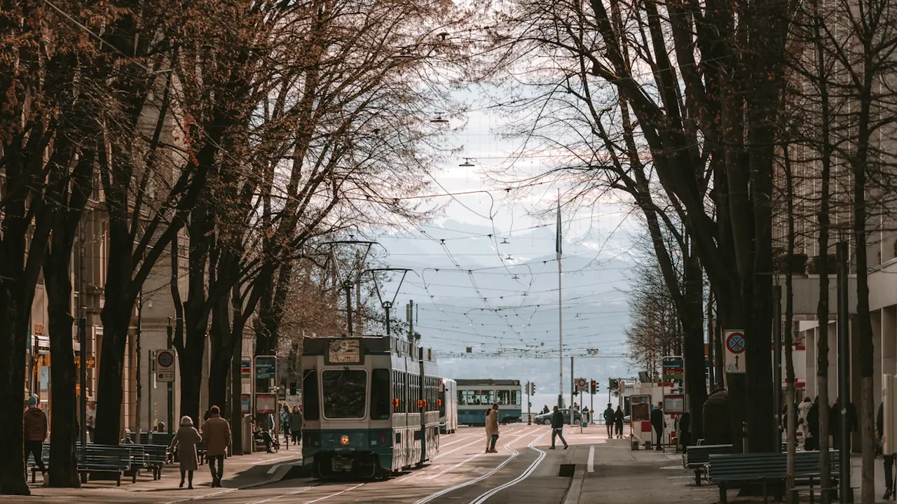 Tramvaja satiksme Cīrihes ielā, kas simbolizē ilgtspējīgu sabiedrisko transportu Eiropas pilsētvidē.