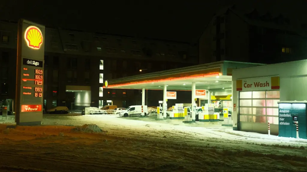 Degvielas uzpildes stacija vakarā ar sniegu, kas raksturīgs Latvijas ziemas apstākļiem.